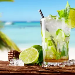 Orzeźwiający koktajl z limonką i miętą na plaży. Idealny przepis na to, jak zrobić mojito w letni dzień.