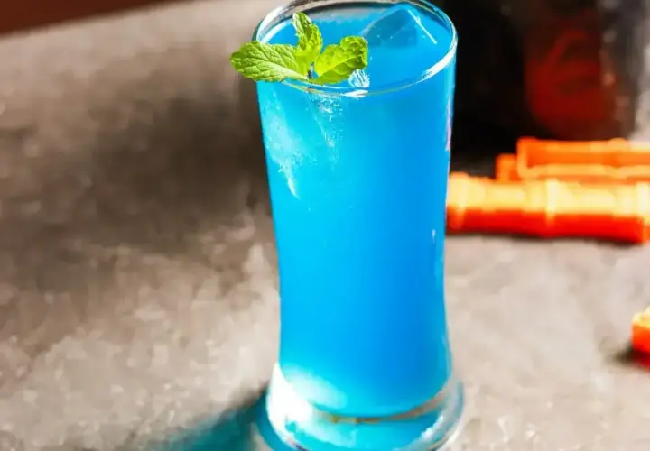 Orzeźwiające drinki z blue curacao, ozdobione listkami mięty, kuszą intensywnym kolorem. Idealne na letnie wieczory.