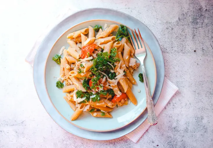 Penne z kawałkami salsiccia, pomidorami i parmezanem. Pyszne danie, które odpowiada na pytanie: salsiccia co to?