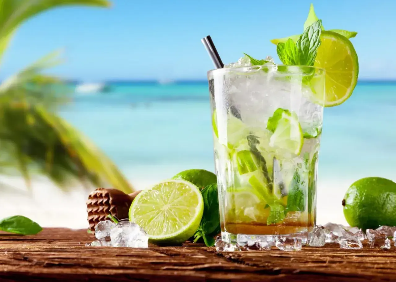 Orzeźwiający koktajl z limonką i miętą na plaży. Idealny przepis na to, jak zrobić mojito w letni dzień.